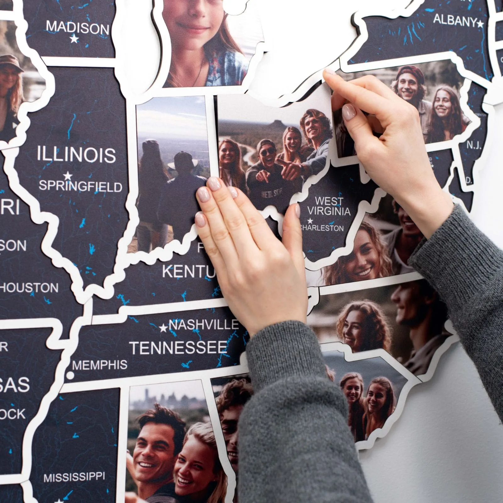 Hands placing a state-shaped photo into a wooden USA photo map
