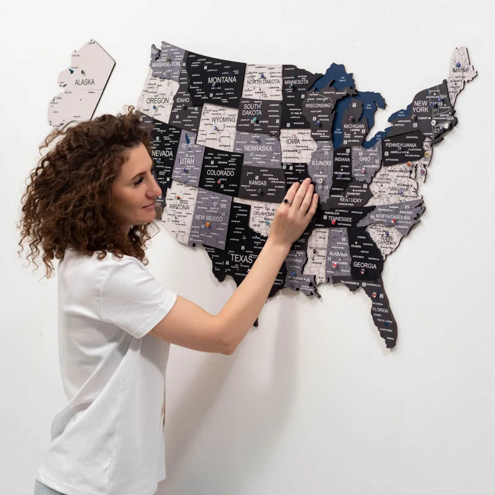 Nordik finish wooden USA map with push pins on a white wall